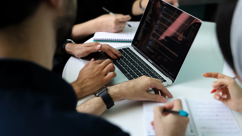 Equipe analisando informações em um notebook durante reunião de planejamento
